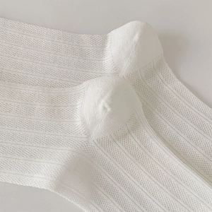 Close-up of white breathable mesh texture and ribbed knit structure on the cotton sock