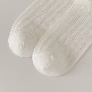 Close-up of white breathable mesh socks with vertical ribbed texture and flat toe seams