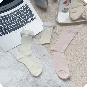 Detail of lace frill cuffs and bow accents on breathable mesh mid-calf socks