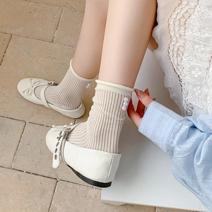Close-up of ballet style sheer socks with pearl accents and ribbed texture detailing