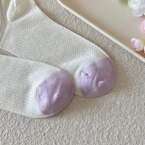 Detail of breathable mesh knit fabric and contrast toe seam on cream and purple socks