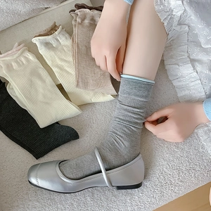 Nahaufnahme grauer Baumwollsocken mit gewelltem Rollrand und vertikalen Streifen
