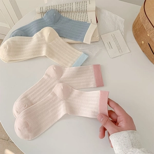 Detail of breathable cotton crew socks in blue, pink and beige with vertical ribbed texture