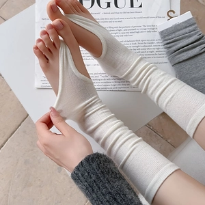 Beige ribbed knit stirrup leg warmers shown with high elasticity for yoga and ballet
