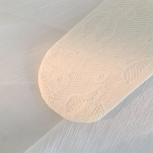 Gros plan sur le motif délicat en dentelle blanche tricotée avec broderie ajourée
