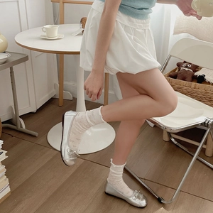 Silver metallic ballet flats with bow detail paired with white ruffled lace socks