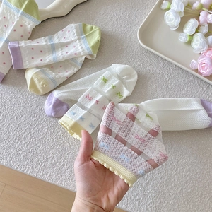 Detail of macaron-colored mesh socks featuring cute polka dots and ruffled edges