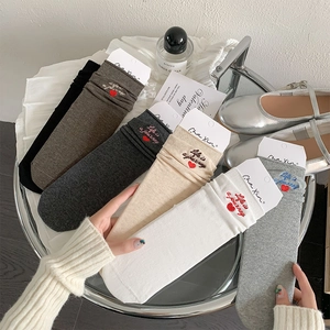 Close-up of cotton mid-calf socks with letter embroidery and red heart in six assorted colors