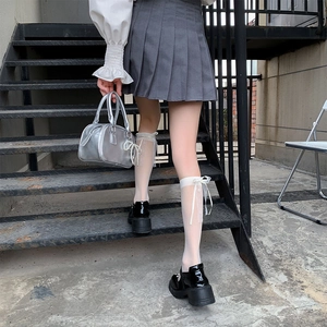 Close-up of Lolita style white lace calf socks with ribbons and black platform shoes