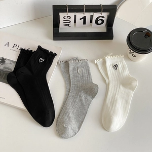 Close-up of sweet heart embroidery and ruffle edge on white, grey and black socks