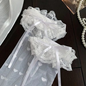 Close-up of white lace bow socks with delicate heart jacquard pattern on a mesh fabric