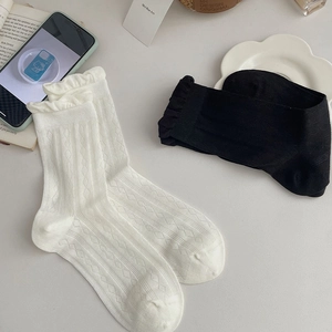 Detail of cute frilly ankle socks featuring vintage diamond knit patterns in black and white