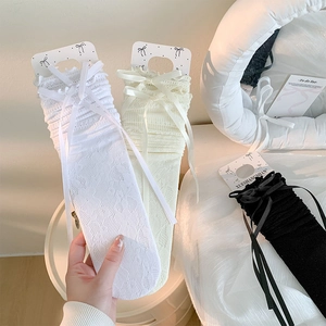 Gros plan détaillé sur la dentelle crochetée et le nœud en satin des chaussettes