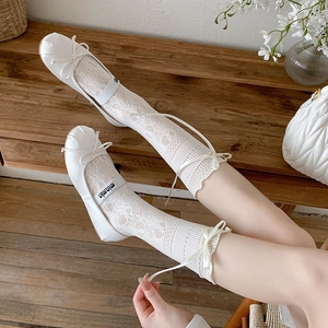Détail de chaussettes en dentelle blanche et ballerines Mary Jane avec nœuds