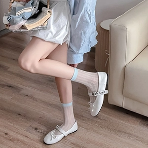 Close-up of white mesh socks with light blue contrast trim and bow Mary Jane shoes