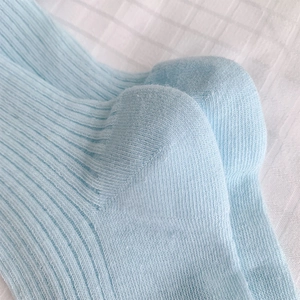 Vue macro de chaussettes bleu clair style ballerine avec maille côtelée et détails de couture