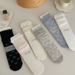 Detail of ruffled lace trim and bow jacquard pattern on sheer breathable crew socks