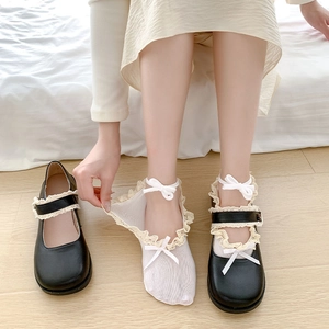 Close-up of white lace mesh socks with ribbon bows paired with black Mary Jane shoes