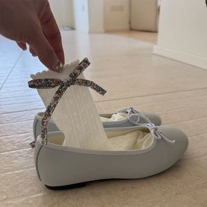 Détails de chaussettes résille blanches à nœud fleuri et ballerines bleues élégantes