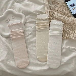 Close-up of ruffled cuff socks with 3D bow patterns in pink, yellow and white