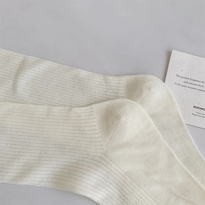 Nahaufnahme cremeweißer Baumwollsocken mit strukturierter vertikaler Rippenstrick-Optik