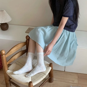 Detail of white crew socks with blue polka dots paired with vintage Korean style outfit