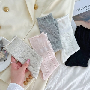 Detailed view of hollow mesh knit socks with ruffled edges in five soft neutral colors