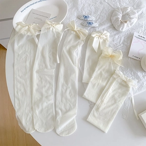 Flat lay of Japanese Lolita thin white sheer socks with lace trim and silk ribbons