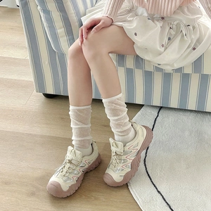 Detailed close-up of retro cream sports sneakers with pink accents and chunky sole
