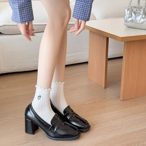 Women's black loafers with white heart embroidery ruffle socks in home setting