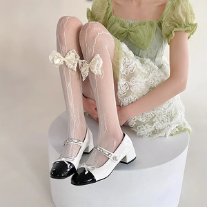 Close-up of white lace mesh stockings featuring a bow detail and Mary Jane shoes