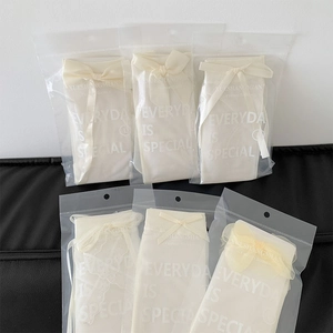 Detail of cream Lolita mesh socks with ribbon bows in individual transparent packaging