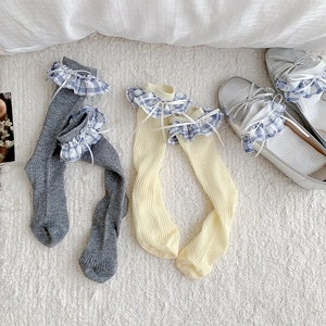 Détail de chaussettes style ballet avec dentelle à carreaux, nœuds et coton côtelé