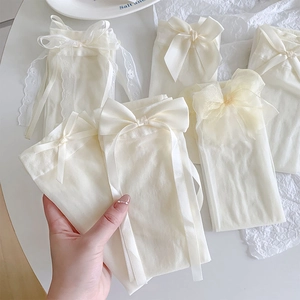 Close-up of cream white Lolita mesh socks featuring silk ribbons and lace bow details