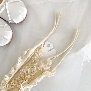 Detailed view of ballet-style lace socks with ribbons and ivory silk mary jane shoes