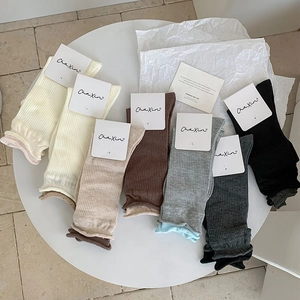 Detaillierte Nahaufnahme bunter gerippter Socken mit stylischen Rüschenbündchen auf Tisch