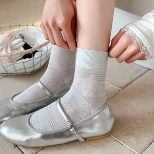 Close-up of light green mesh socks with pointelle texture paired with silver Mary Janes