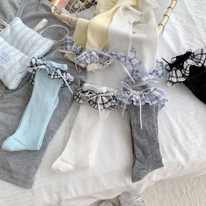Détail de chaussettes en coton style ballet avec dentelle à carreaux et nœud doux