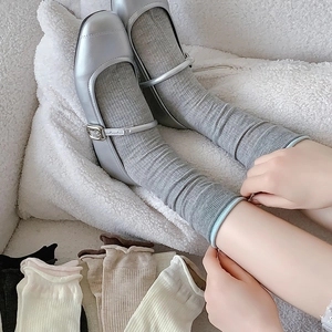 Senkrecht gestreifte Crew-Socken in verschiedenen Farben an Model und flach liegend