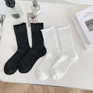 Detail of white and black lettuce edge socks showing breathable knit cotton texture