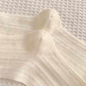Détail de chaussettes en maille pointelle crème avec des bords en dentelle délicats