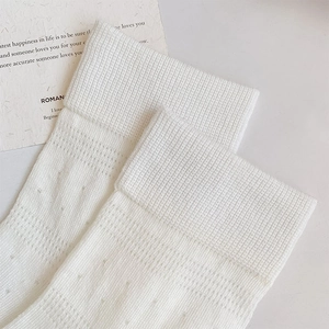 Detailed close-up of white breathable mesh knit socks with elegant hollow-out patterns