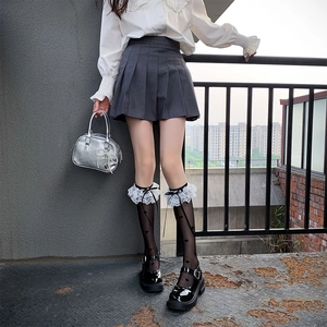 Japanese Lolita style white lace socks with bows paired with gray pleated skirt and Mary Janes