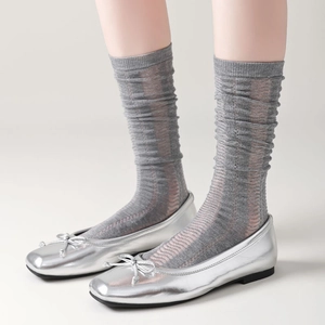 Silver ballet flats with bows and grey striped calf socks in a minimalist 45-degree view