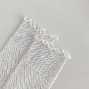 Close-up of white mesh socks with ruffled lace edges and delicate breathable texture