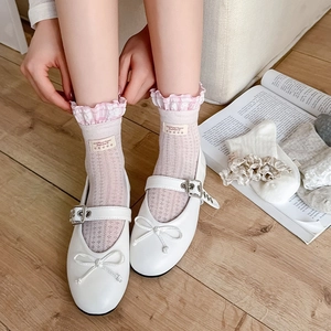 Detail of ballet style white socks with pink plaid lace trim and fabric label tags