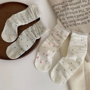 Detail of four floral mesh crew socks with lace trim and vintage knit patterns