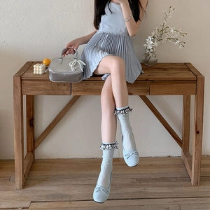 Détail de chaussettes bleu clair style ballerine avec dentelle noire et nœuds