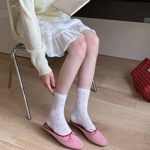 Detailed macro of white mesh lace socks with floral embroidery and pink bow loafers