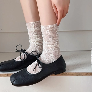 Detailed view of white floral lace calf socks with delicate crochet patterns and sheer texture